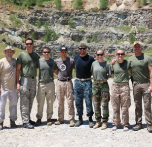 A group of male and female military trainees standing shoulder-to-shoulder in military and tactical gear at the PTF outdoor quarry training range.